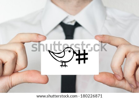 Social media hashtag tweet. Businessman in white shirt with a black tie showing or holding business card
