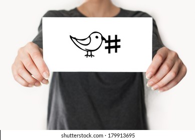 Social media hashtag twitter. Female in black shirt showing or holding a card