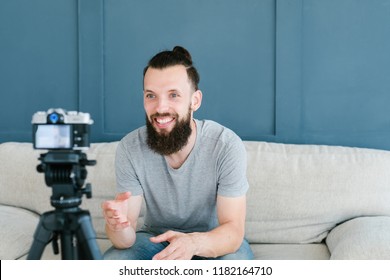 Social Media Influencer Creating Content. Man Shooting Video Of Himself Using Camera On Tripod. Smiling Bearded Hipster Guy Communicating With Subscribers.