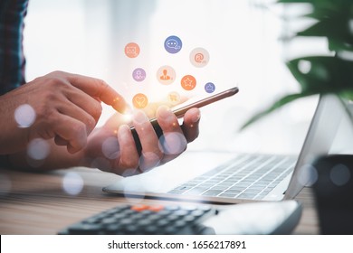 Social media interactions on mobile phone, concept with notification icons of like, message, email, comment and star above smartphone screen, person hands holding device, internet digital marketing - Powered by Shutterstock