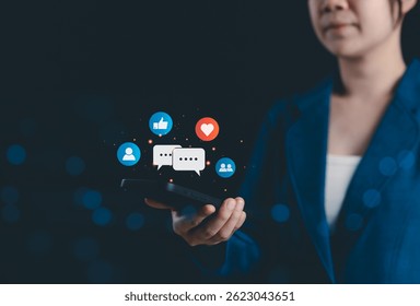 Social Media Network Engagement and Online Communication Concept. Woman holding smartphone with social media icons like thumbs up, chat bubbles, heart, and user groups. digital marketing, interaction,