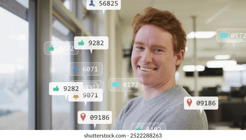 Social media notifications image over man standing by window in office. Technology, communication, digital, smartphone, interaction, business - Powered by Shutterstock