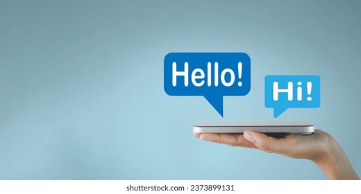 Social media,Possitive emotions,Greeting concept.,Hand holding smartphone with Hello and Hi word in speech bubble icon over blue background with copyspace idea for technology,communication. - Powered by Shutterstock