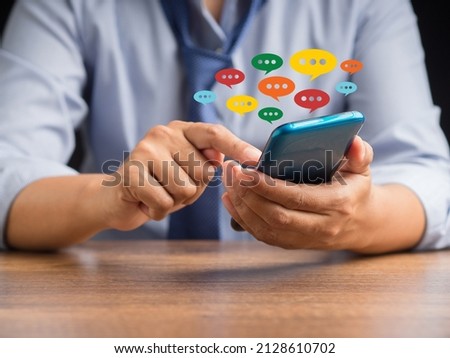Social network and live chat chatting concept. Close-up of hands using mobile phone with colorful chat icons on application communication digital web and social media
