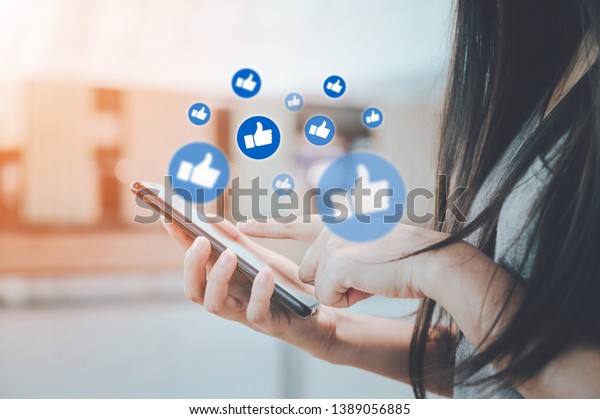 Social network sharing and commenting in the online\
community, Woman hand holding smartphone and using application\
social media