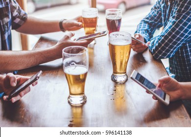 Social networking with beer glasses in bar. Focus on beer glasses - Powered by Shutterstock