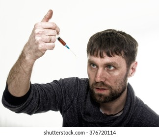 The Social Problem - Addiction. Young Sad Man Holding Syringe To Drug Use.