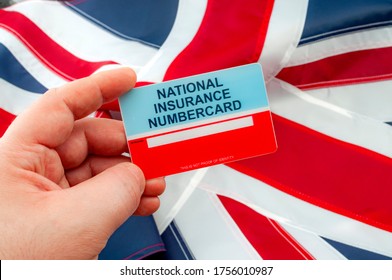 Social Security System, Access To Safety Net Programs In Great Britain Concept Theme With A Blank National Insurance Number Card Or NINO Held In One Hand With The UK Flag In The Background
