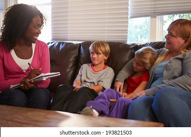 Social Worker Talking To Mother And Children At Home
