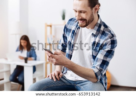Socially active vibrant guy reading the newsfeed