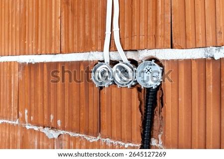 Socket back boxes with wires in a brick wall. New electrical wiring installation