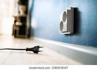 Socket and power outlet. Electric plug. Cable unplugged from wall. Wire and cord. Electricity off. Energy consumption, crisis or saving. Electrical current at home in Europe. Household technology.