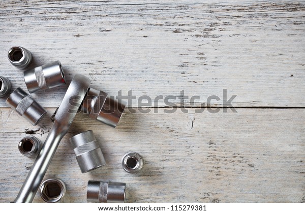 Socket wrench on\
painted wood background