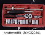 A socket wrench tool set with a ratchet and various sockets in a red plastic case. Image for mechanics, repair, and DIY concepts