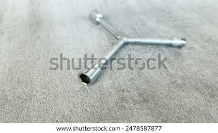 Socket Y key (because it is shaped like the letter Y) or triangle wrench to make it easier to remove or install bolts or nuts on motorbikes on a gray background