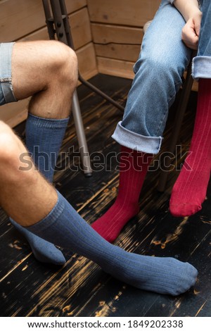 Socks close up. The guy and the girl on a wooden ladder sit. For advertising.