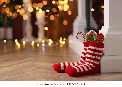 Socks filled with sweets on floor in room, space for text. Saint Nicholas Day - Powered by Shutterstock