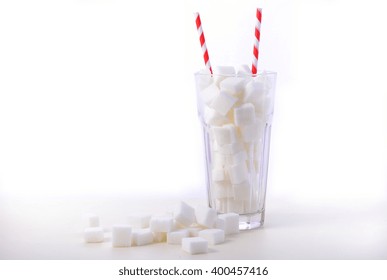 Soda Glass Of White Sugar Cubes With Red And White Straws On White Wooden Table 