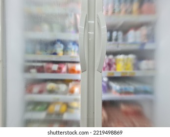 Soda Pop And Soft Drinks In The Fridge.  Glass Door Refrigerator Condensed.  Soda Pop Cans And Plastic Bottles In Vertical Freezer In Supermarket.