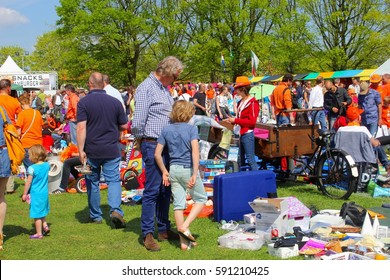 SOEST, NETHERLANDS - April 27, 2016. Father And Son Are Shopping For Secondhand Children Games And Used Kids Toys At Outdoor Vrijmarkt Flea Market On Koningsdag (Kingsday). 