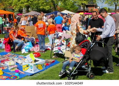 SOEST, NETHERLANDS - April 27, 2017. Mother, Father And Little Son In Buggy Are Looking For Secondhand Children Games And Used Toys At Traditional Vrijmarkt Flea Market On Koningsdag (Kingsday).