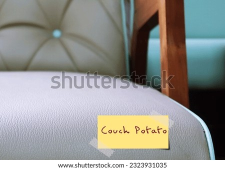 Sofa with handwritten stick note COUCH POTATO, refers to person who lives sedentary lifestyle, lazy and inactive person who watch TV and eats junk food all the time