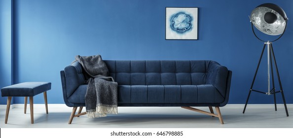 Sofa and lamp in modern minimalistic blue room 