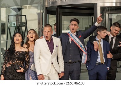 Sofia, Bulgaria - 24.05.2022, A Group Of Students In Fancy Dresses Shouts Emotionally The Celepration Of The Graduate Prom Near The Entrance Of A Restaurant