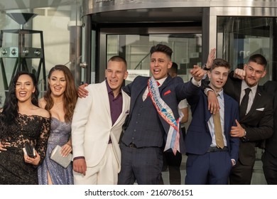 Sofia, Bulgaria - 24.05.2022, A Group Of Students In Fancy Dresses Shouts Emotionally The Celepration Of The Graduate Prom Near The Entrance Of A Restaurant