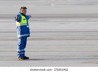 Sofia, Bulgaria - April 11, 2015: An Airport Worker Is Navigating The Movement Of An Airplane On The Airport Runway After Landing.
