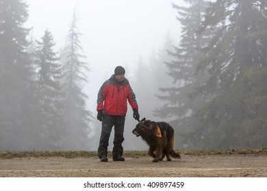 Sofia, Bulgaria - April 20, 2016: A Man And His Dog At The Search And Rescue Team At Bulgarian Red Cross Are Participating In A Training In The Foggy Mountain. 