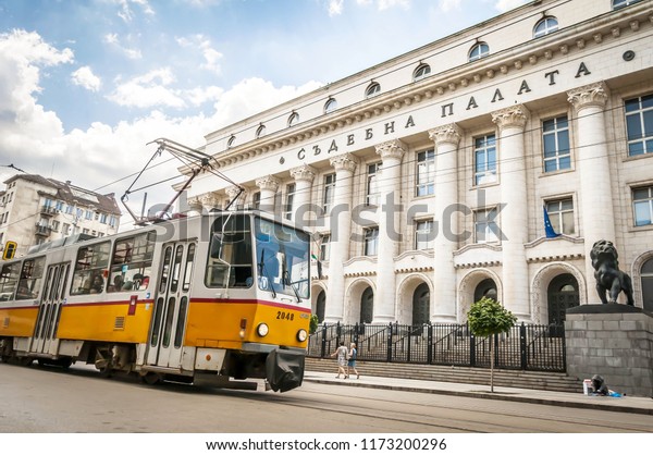 SOFIA, BULGARIA. August 4, 2018. Old fashioned\
orange Soviet style city tram street car KTM-5M3 (71-605) model in\
front of the Bulgarian Court Chamber (Palace of Justice) building\
in downtown Sofia.