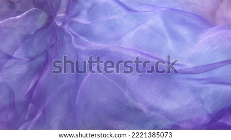 Soft background in blues, mauves and pinks created with light playing on coloured silks