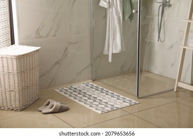 Soft Bath Mat And Slippers On Floor In Bathroom