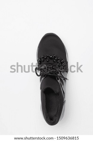 Soft black women's shoes, decorated with beads on a white background. Top view. Space for text.