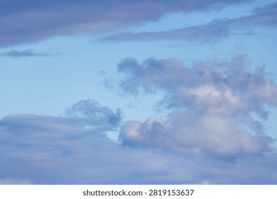 Soft blue cloudscape with layered twilight clouds and open sky, evoking calm, serene and airy feelings.