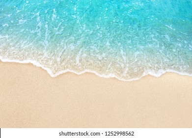 Soft blue ocean wave on clean sandy beach - Shutterstock ID 1252998562