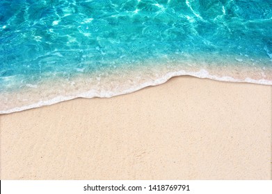 Soft blue ocean wave on clean sandy beach - Shutterstock ID 1418769791