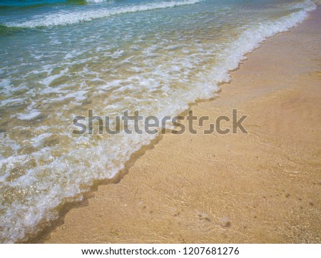 Soft blue ocean wave on sandy beach. Bottom. White sand on the beach with turquoise water in Djerba, Tunisia.
