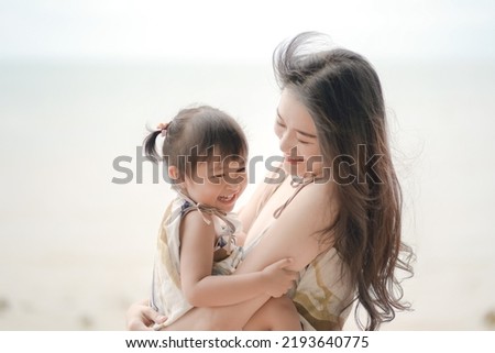 Soft and blurred portrait of asian young woman and her daughter hugging and laughing together. Lovely family concept.