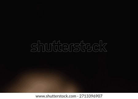 Soft blurred warm light floating in deep darkness. 