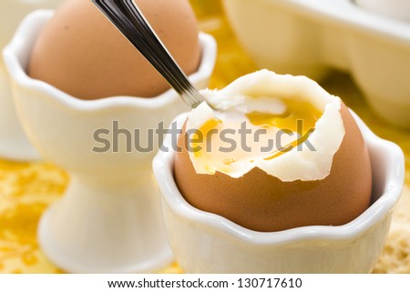 Soft boiled egg in egg cup and served with toast fingers.