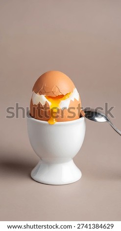 Soft boiled egg in a white eggcup with a spoon