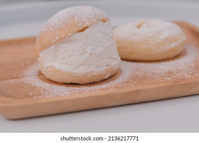 Soft buns filled with creamy are placed in a wooden dish sprinkled with icing sugar.Homemade confectionery,bakery business,baking school or cafe concept,high-energy snacks containing starch and sugar. - Powered by Shutterstock