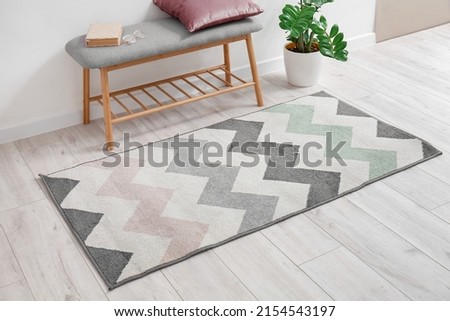 Soft carpet and comfortable bench on light wooden floor in room interior