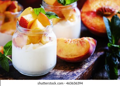 Soft cheese with sliced peach slices, dark wood background, selective focus