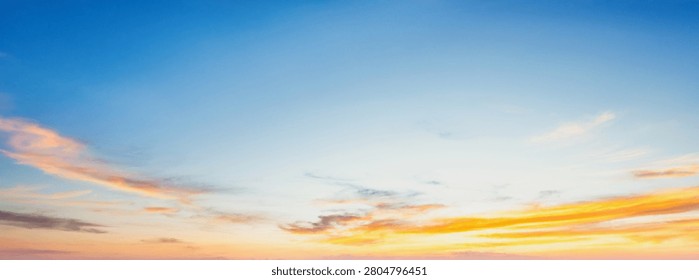 Soft clouds drift across a glowing sky. Golden hues blend with twilight blue. Peaceful dusk blankets the horizon gently