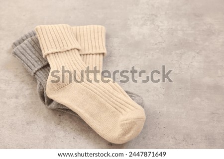 Soft comfortable socks on grey table, closeup. Space for text