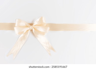 Una cinta amarilla suave y cremosa está elegantemente atada en un lazo en el lado izquierdo de un fondo blanco brillante.