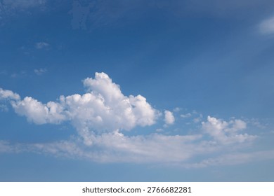 Soft cumulus clouds float across a vivid blue sky, evoking calm, openness and summer serenity. Minimal composition with gentle light ideal for backgrounds, weather concepts, or nature themes.